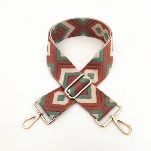 Close-up of geometric ethnic woven bag strap with golden metal lobster clasps