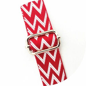 Close-up of red and white chevron strap with light gold adjustable metal buckle