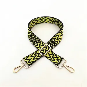 Detail view of yellow and black geometric ethnic woven strap with golden metal clasps