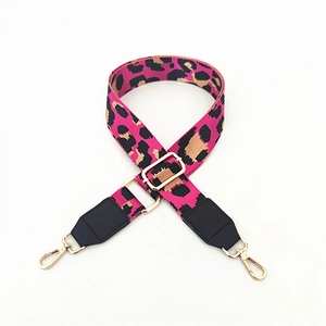 Detail of adjustable leopard print bag strap with gold metal hooks and black leather ends