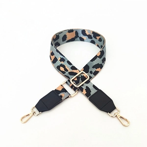 Close-up of adjustable leopard print bag strap with golden metal hooks and black leather ends