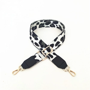 Detail of adjustable leopard print bag strap with golden lobster claws and leather ends