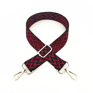 Detail of red and black geometric woven bag strap with golden rotating metal hooks