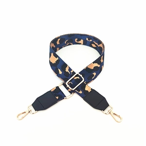 Close-up of leopard print nylon bag strap with adjustable metal buckle and gold lobster hooks