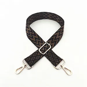 Close-up of ethnic geometric woven bag strap with vintage patterns and gold metal clips