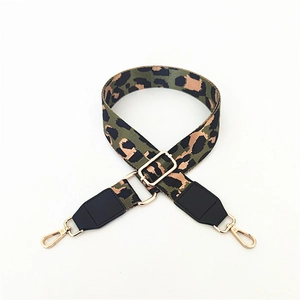 Detail of adjustable leopard print bag strap with golden metal hardware and black leather ends