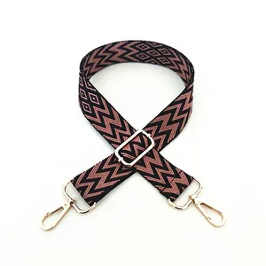 Close-up of adjustable woven shoulder strap with geometric patterns and gold metal buckles
