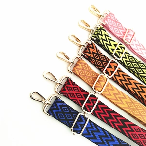 Close-up of adjustable woven shoulder straps with geometric patterns and gold metal clips
