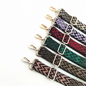 Close-up of adjustable woven shoulder strap with gold-tone clips and ethnic wave pattern