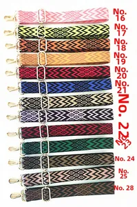 Close-up of 13 colorful ethnic style adjustable bag straps with gold metal hooks and buckles