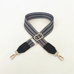 Detail of adjustable woven shoulder strap with black geometric pattern and gold hardware