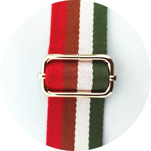 Detail of colorful striped woven bag strap with a polished gold adjustable buckle