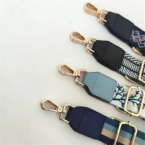 Detail view of adjustable crossbody straps with gold lobster clasps and patterns