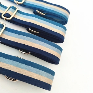 Close-up of adjustable striped canvas strap with gold hardware and woven texture