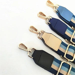 Detailed view of adjustable striped woven straps with gold-finished metal buckles