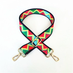 Detail of colorful geometric woven strap with golden lobster clasps and metal slider