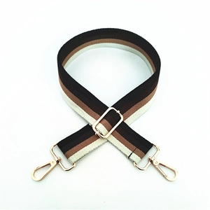 Detail of adjustable striped woven shoulder strap with gold metal hooks and buckle