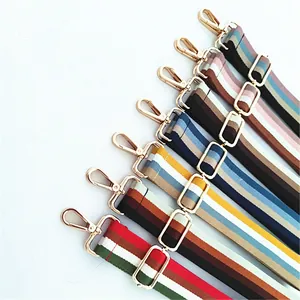 Detailed view of adjustable striped cotton bag straps with gold metal lobster clasps