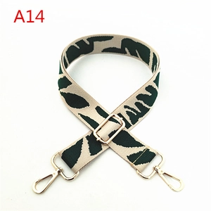 Close-up of ethnic style shoulder strap with dark green leaf pattern and gold hardware