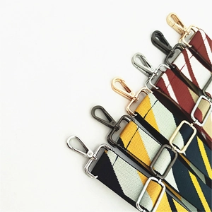 Detail of adjustable woven bag straps with colorful patterns and metallic swivel hooks