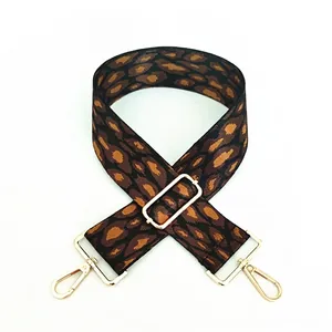 Detailed view of leopard print bag strap with golden metal lobster clasps and adjuster