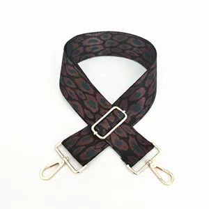 Adjustable leopard print bag strap with gold metal hardware and green brown webbing