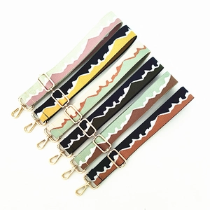 Detail showing six colorful wave-patterned woven bag straps with gold metal hardware