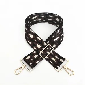 Macro shot of adjustable leopard print bag strap with polished gold metal hardware