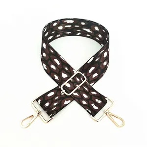 Detail view of adjustable leopard print bag strap with polished gold-tone metal hooks