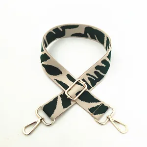 Adjustable green and beige patterned shoulder strap with gold metal hooks for handbags