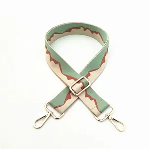 Adjustable wide fabric bag strap with mint green wave pattern and gold metal hooks