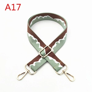 Detail view of adjustable canvas shoulder strap with wave pattern and golden metal hooks