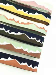 Close-up of woven jacquard shoulder strap featuring colorful mountain landscape patterns