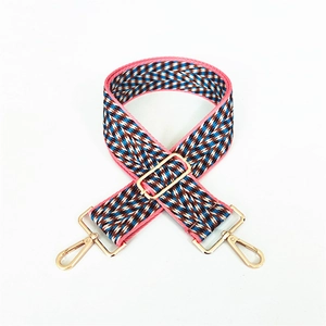 Close-up of colorful jacquard woven bag strap with adjustable gold-tone metal buckle