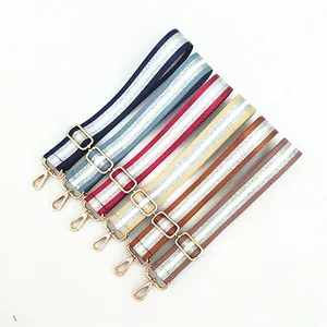 Detail of adjustable woven purse straps in multiple colors with gold metal lobster clasps