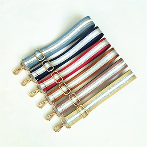 Detail of adjustable woven bag straps in multiple colors with shiny stripes and gold hooks