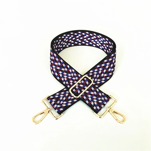 Close-up of red and blue zigzag jacquard bag strap with golden lobster metal clasps