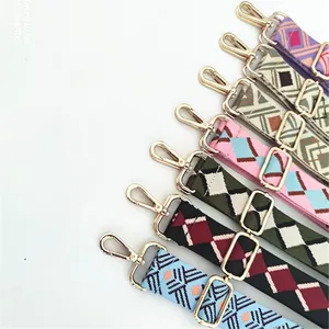 Detail of adjustable ethnic style bag straps with colorful patterns and golden metal hooks
