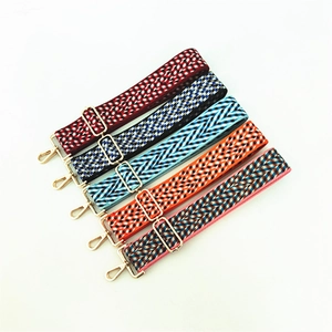 Detail of five colorful woven adjustable shoulder straps with gold metal hooks and buckles