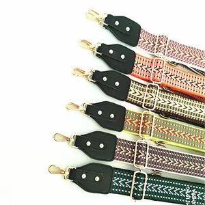 Close-up of bohemian jacquard bag strap with leather details and gold metal hooks