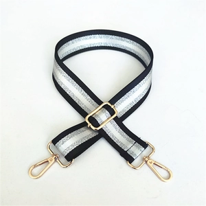 Close-up of adjustable black and silver striped bag strap with gold metal swivel hooks