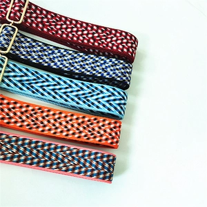 Macro detail of multi-color herringbone patterned woven straps with golden metal buckles