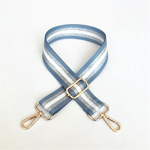 Close-up of adjustable light blue and silver striped bag strap with gold metal hardware