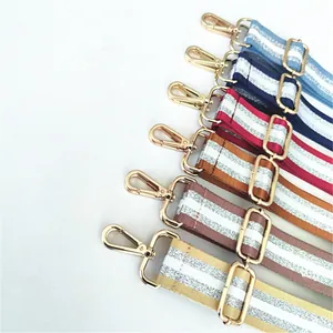 Detail of adjustable woven shoulder straps with glitter stripes and gold metal hooks