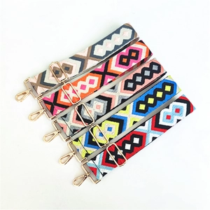 Adjustable ethnic style embroidery bag straps with gold metal hooks on white background
