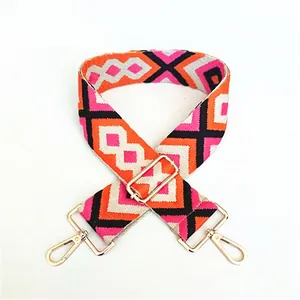 Detail of adjustable ethnic style woven strap with orange geometric patterns and gold clips