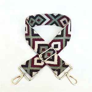 Close-up of ethnic woven handbag strap with geometric patterns and gold metal buckles