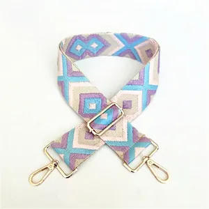 Detail of blue and purple geometric ethnic style woven strap with golden metal clasps