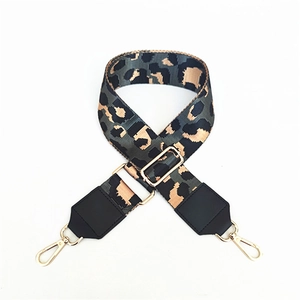 Close-up of leopard print wide crossbody strap with gold metal hooks and black leather ends