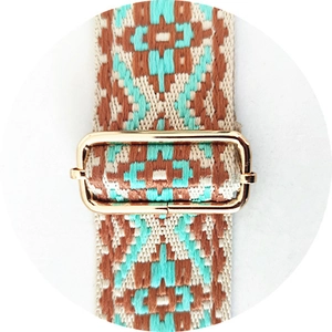 Macro detail of ethnic woven bag strap with golden metal adjustment buckle